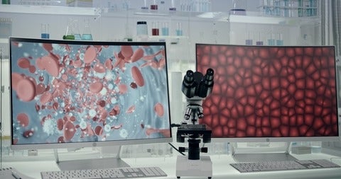 Futuristic laboratory equipment with blood cells research on computer screens