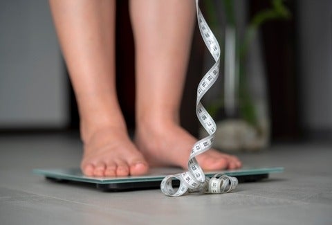 A person checking their weight and height. (Getty Images/Fotolgahan)