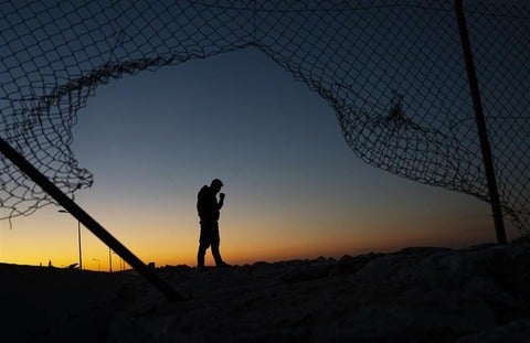 the silhouette of a man surrounded by a fence