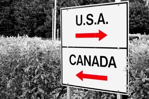 Direction signs on post featuring arrow and the words "U.S.A" and "Canada"