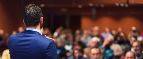 Rear view of speaker giving a talk on corporate Business Conference