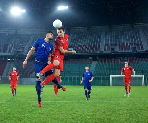 Soccer player jumping and heading the ball.