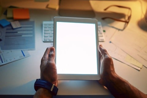 Cropped shot of an unrecognizable man using a digital tablet during a late night at work