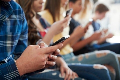 Close up of adolescents using mobile phones 