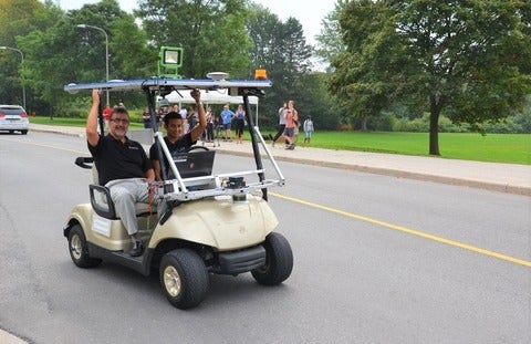 Feridun Hamdullahpur and Alex Rodrigues in a self-driving golf cart during testing in 2015 at the University of Waterloo.