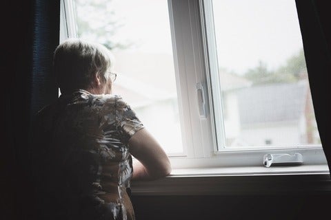 Senior woman looking out window