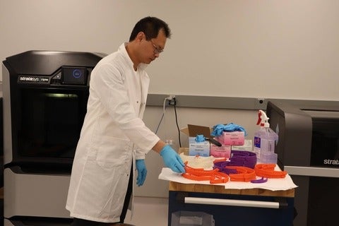 Jerry Ratthapakdee, a MSAM lab technician, takes a completed headband out of a 3D printer in Waterloo’s Multi-