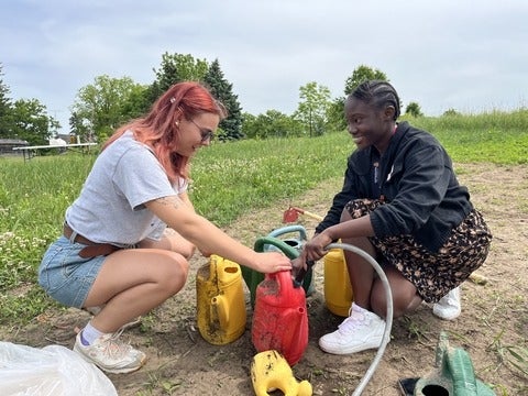 High school student watering plants in garden