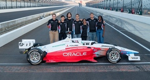 Members of team with their car at Indy Autonomous Challenge.