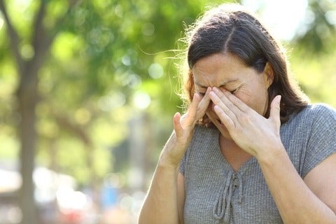 Woman rubs eyes with her hands
