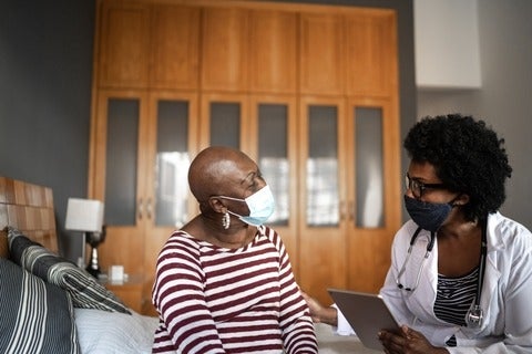 A medical personnel speaks with a patient. 