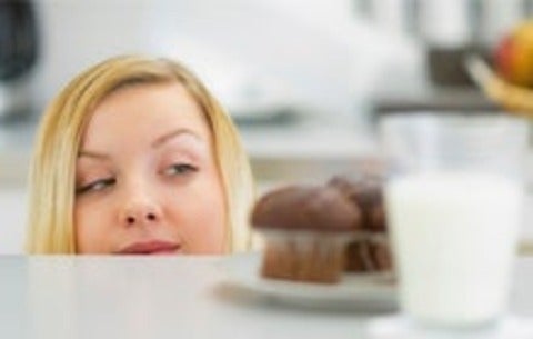 Woman eyeing up a cupcake