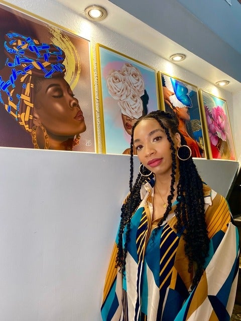 Kemahee Baker poses with her paintings