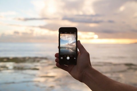 Using a phone to take a photo of the horizon. 