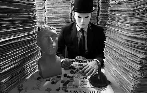 Man in a mask holding a magnifying glass over a newspaper