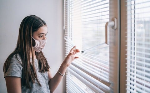 Girl in face mask at home during virus