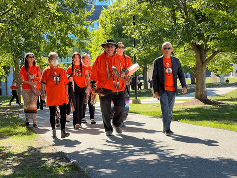 Elder Henry walking with Goel and others wearing orange shirts