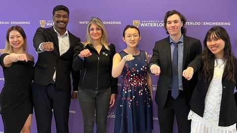 Engineering students and professor show off their iron rings