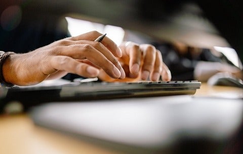 Hands typing on computer