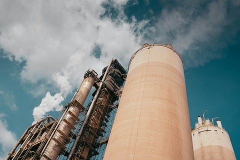 A view of smoke stacks with smoke coming out of them