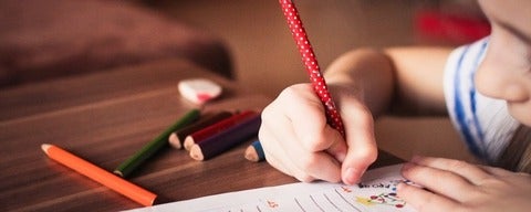 Child at desk drawing on paper
