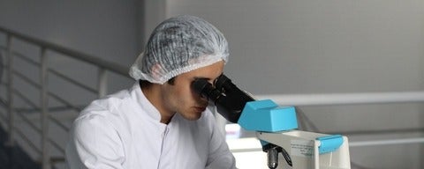 Doctor looking through medical microscope