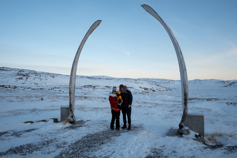Jenna and Chris with their baby bundled up in a snow landscape in the North