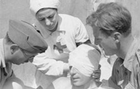 Doctors and nurse aid an injured man during World War 1