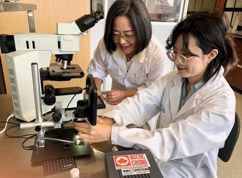 Dr. Carolyn Ren (left) works with new technology to detect E. coli bacteria in water with PhD student Qianying (Alice) Mao in he