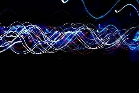 wavering coloured lines across dark background
