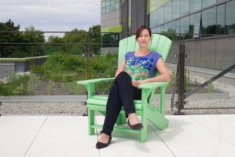 Director Sarar Burch sitting on a green muskoka chair