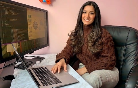 Sara Ibrahim sitting at her computer, looking at the children's story