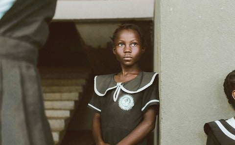 African girl standing in her school uniform