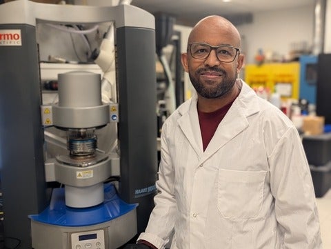 Waterloo researcher Dr. Tizazu Mekonnen stands next to a rheometer, which is used to test the flow properties of hydrogels.