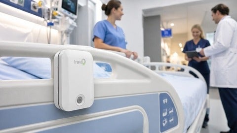Trevii unit is attached to the side of a hospital bed with medical staff in the background