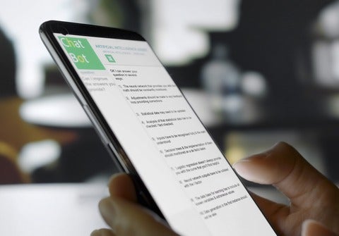 A person interacts with an AI chatbot on a smartphone, asking questions and receiving real-time responses.