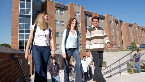 Two female and one male students walking from Mackenzie King Village residence stairs
