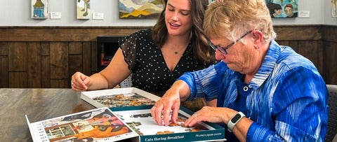 Olivia Vento and her grandmother working on the Piece of Mind Cats Having Breakfast puzzle activity