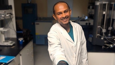 Researcher holding coated seeds.