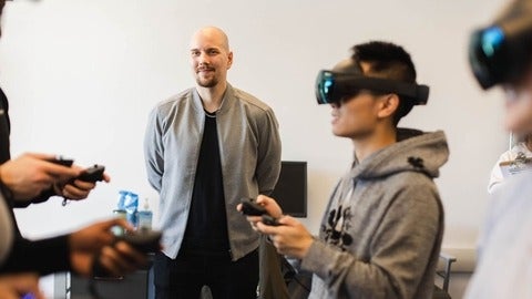 Professor Ville watches a group of students using VR equipment