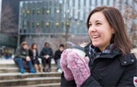 Female student warming her hands on a hot cup of coffee