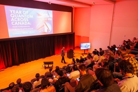Big classroom with students, staff and faculty listening to a presentation on the Year of Quantum across Canada