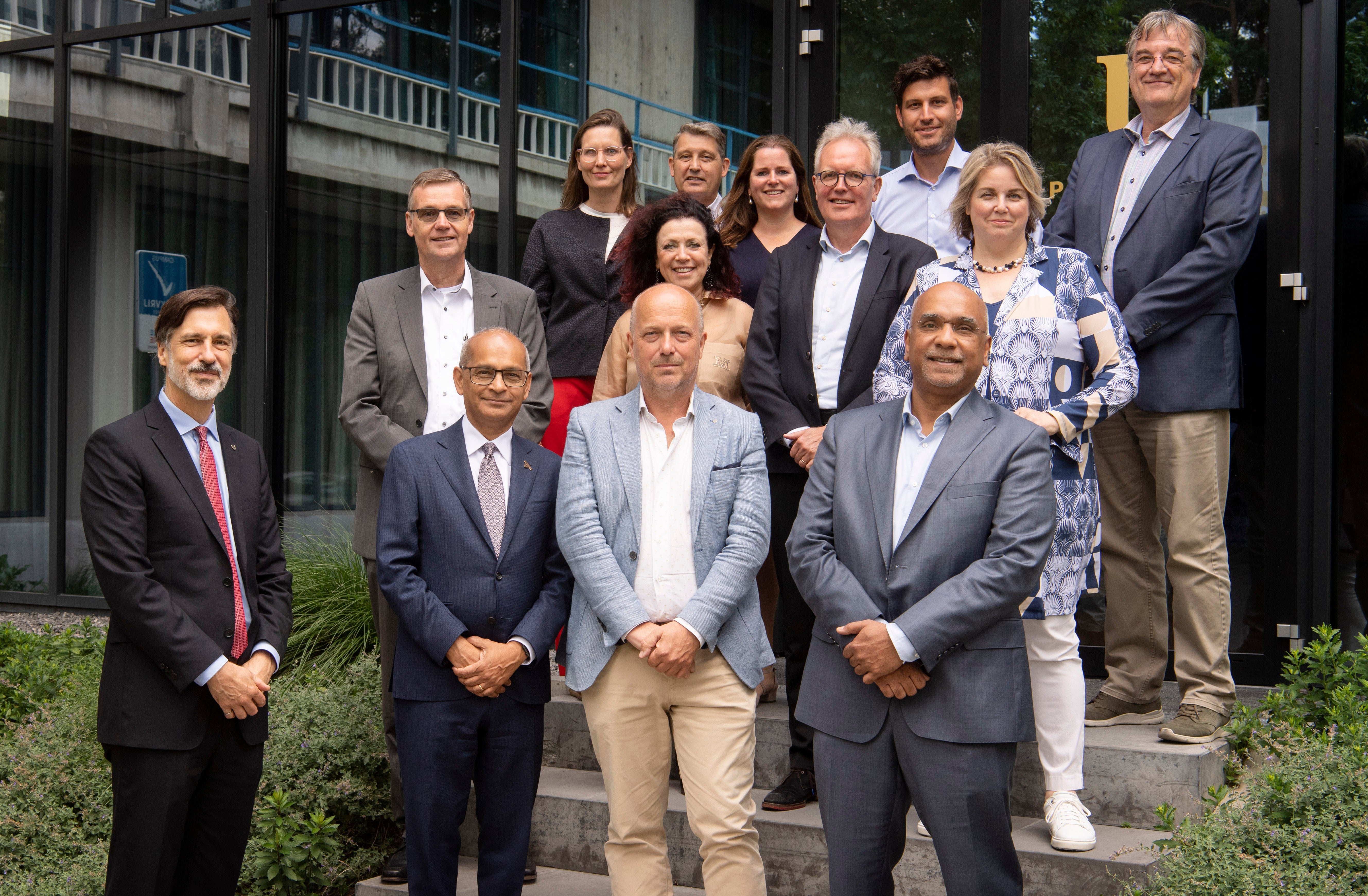 Vivek Goel and Ian Rowlands standing with Twente University delegation outside a building.