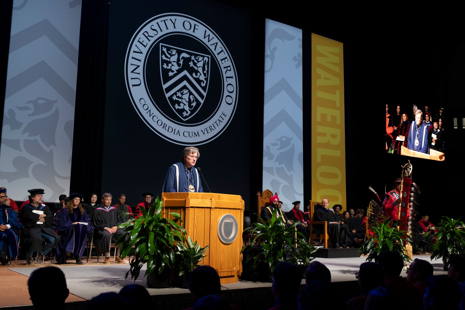 President Bill Rosehart speaks from podium on stage at convocation.