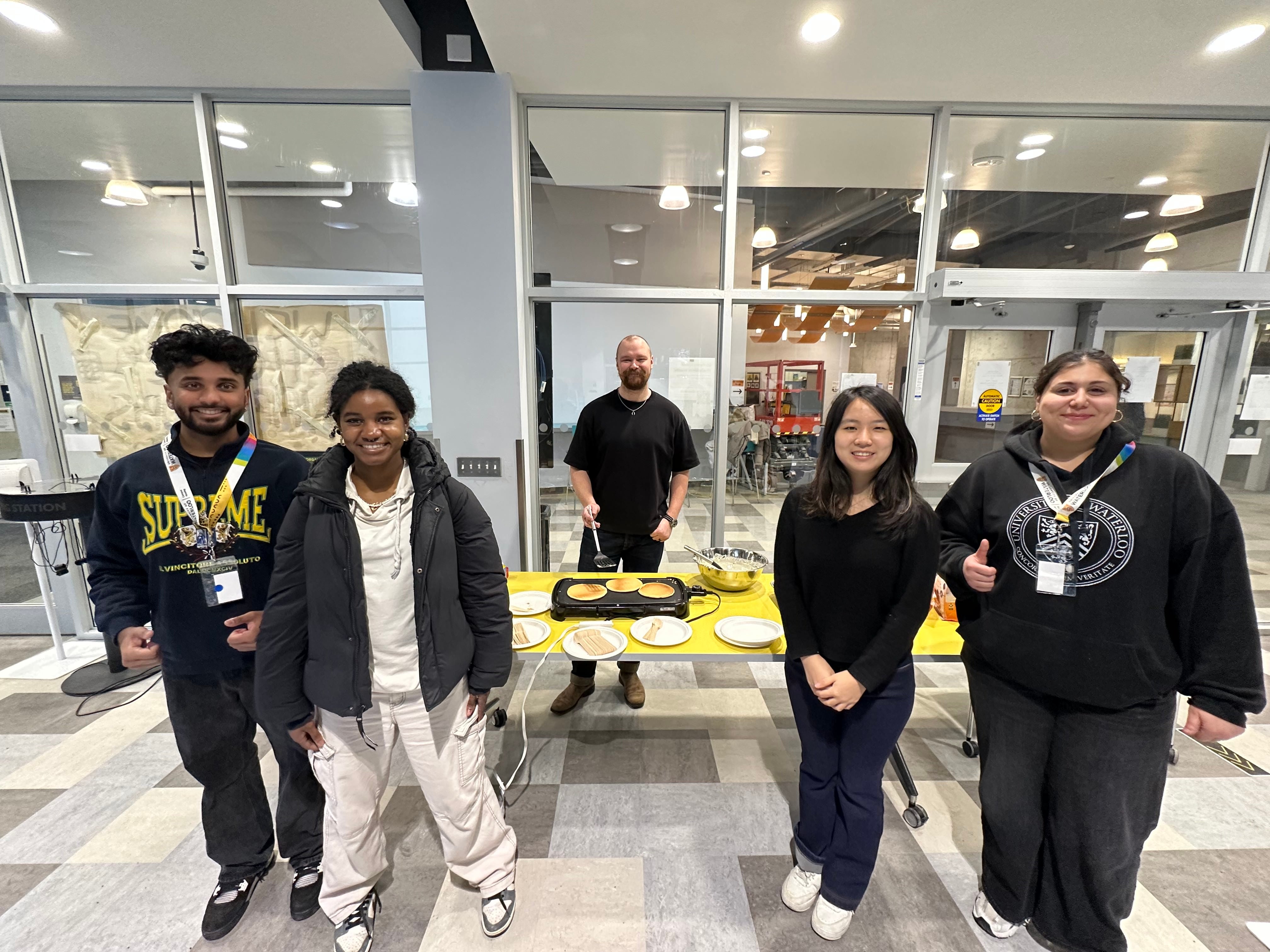 Luke Manimendre and four friends standing in front of pancake event at Claudette Millar Hall