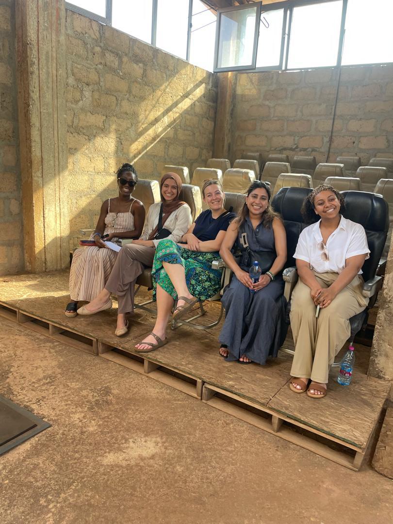 El-shayeb sitting in one of Ghana’s abandoned silos with a group of people. 
