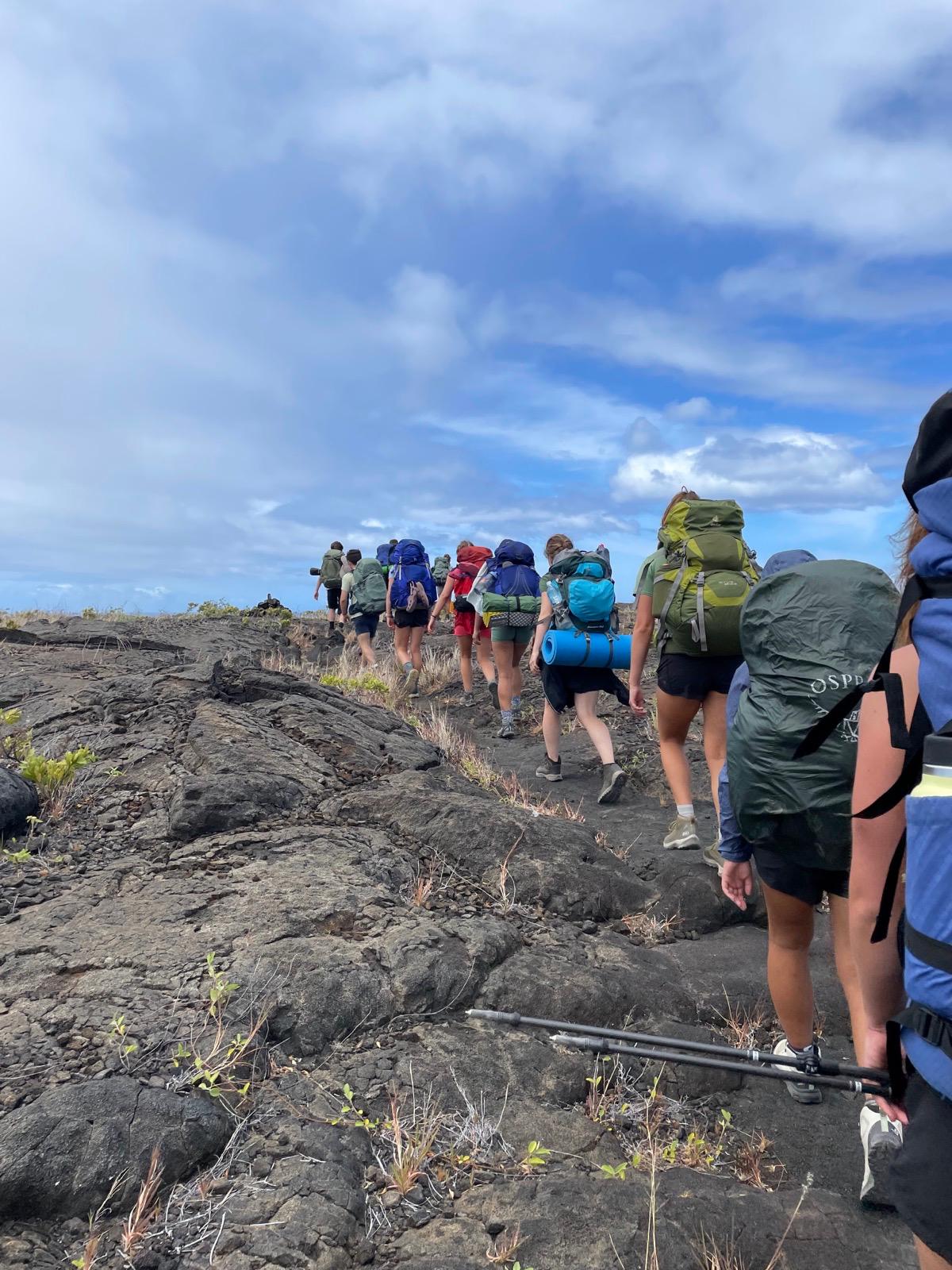 A group of people in a line hiking.