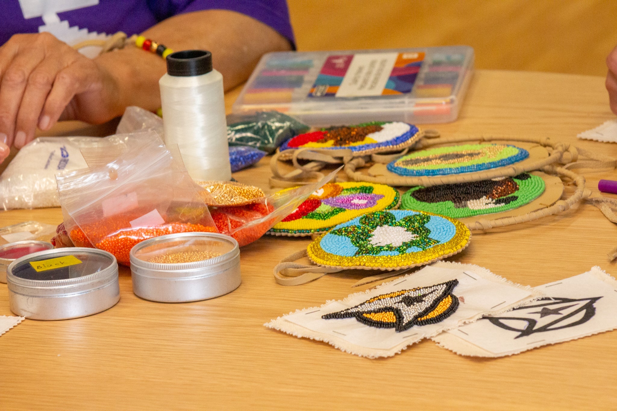 Rhe Green's beadwork designs laid out on a table