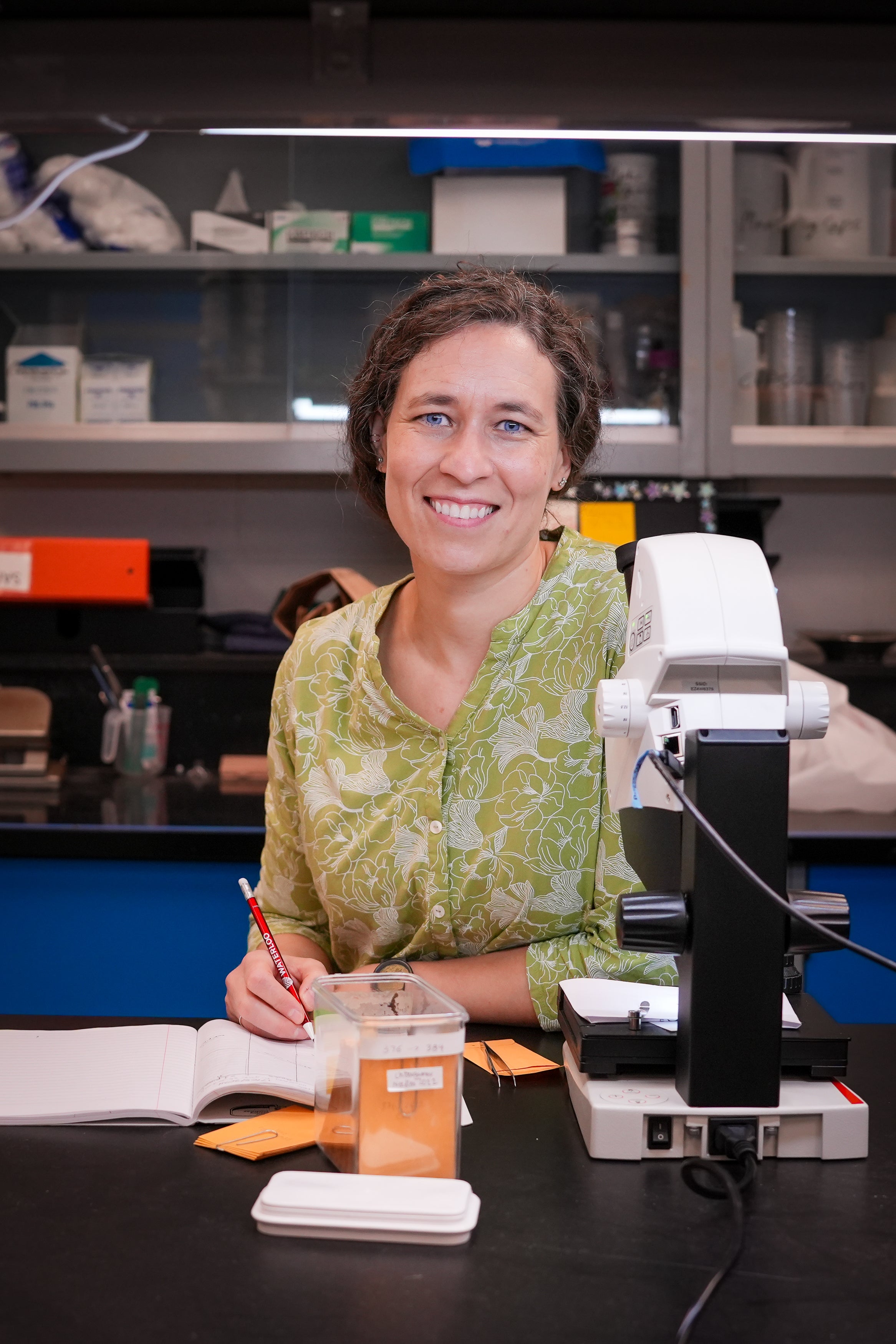 Julie Messier taking notes in her lab.