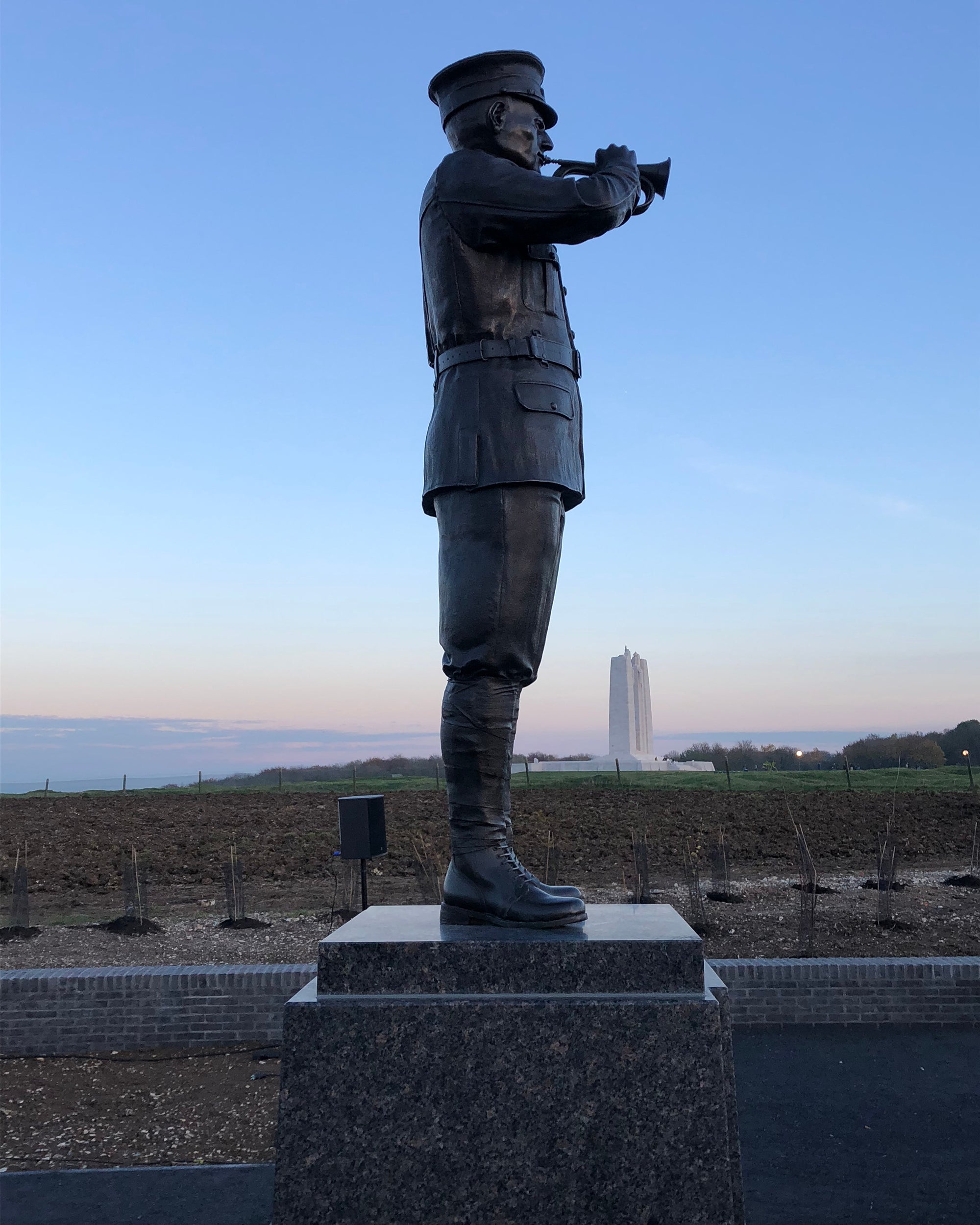  the bugler statue at Centennial Park soars over the repatriated oak saplings